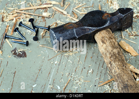 Rustikale alte Hammer mit schwarzen Nägeln auf alten grünen hölzernen Hintergrund - DIY Konzept Stockfoto