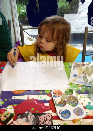 Ein Kind zeichnet ein Bild an einem Tisch Stockfoto