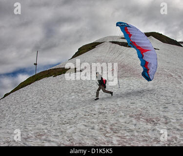 30. Juni 2012 - Girdwood, Alaska, USA - 2 in einer Reihe. Ein Gleitschirm beginnt seinen Lauf, von 2300 Fuß über dem Meeresspiegel an der Nordwand des Mt Alyeska zu starten. Er wird in einem Kabelbaum ausgesetzt unter der bunten Stoff Flügel sitzen. Reservieren Sie Fallschirme, Helm, Stiefeln und Flug-Anzüge sind erforderlich. Mt. Alyeska, der größten Skiberg im Zustand, liegt in Girdwood, Alaska, 27 Meilen (44Â km) von Anchorage, ein Lieblings Startplatz für Gleitschirmflieger. (Kredit-Bild: © Arnold Drapkin/ZUMAPRESS.com) Stockfoto