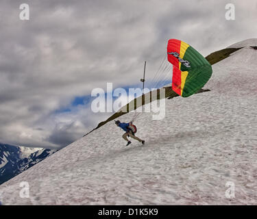 30. Juni 2012 - Girdwood, Alaska, USA - 2 in einer Reihe. Ein Gleitschirm beginnt seinen Lauf, von 2300 Fuß über dem Meeresspiegel an der Nordwand des Mt Alyeska zu starten. Er wird in einem Kabelbaum ausgesetzt unter der bunten Stoff Flügel sitzen. Reservieren Sie Fallschirme, Helm, Stiefeln und Flug-Anzüge sind erforderlich. Mt. Alyeska, der größten Skiberg im Zustand, liegt in Girdwood, Alaska, 27 Meilen (44Â km) von Anchorage, ein Lieblings Startplatz für Gleitschirmflieger. (Kredit-Bild: © Arnold Drapkin/ZUMAPRESS.com) Stockfoto