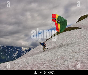 30. Juni 2012 - Girdwood, Alaska, USA - 3 in einer Reihe. Ein Gleitschirm beginnt seinen Lauf, von 2300 Fuß über dem Meeresspiegel an der Nordwand des Mt Alyeska zu starten. Er wird in einem Kabelbaum ausgesetzt unter der bunten Stoff Flügel sitzen. Reservieren Sie Fallschirme, Helm, Stiefeln und Flug-Anzüge sind erforderlich. Mt. Alyeska, der größten Skiberg im Zustand, liegt in Girdwood, Alaska, 27 Meilen (44Â km) von Anchorage, ein Lieblings Startplatz für Gleitschirmflieger. (Kredit-Bild: © Arnold Drapkin/ZUMAPRESS.com) Stockfoto