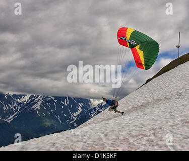 30. Juni 2012 - Girdwood, Alaska, USA - 4 in einer Reihe. Ein Gleitschirm beginnt seinen Lauf, von 2300 Fuß über dem Meeresspiegel an der Nordwand des Mt Alyeska zu starten. Er wird in einem Kabelbaum ausgesetzt unter der bunten Stoff Flügel sitzen. Reservieren Sie Fallschirme, Helm, Stiefeln und Flug-Anzüge sind erforderlich. Mt. Alyeska, der größten Skiberg im Zustand, liegt in Girdwood, Alaska, 27 Meilen (44Â km) von Anchorage, ein Lieblings Startplatz für Gleitschirmflieger. (Kredit-Bild: © Arnold Drapkin/ZUMAPRESS.com) Stockfoto