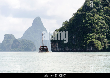 Hölzerne Touristenboot gehen von Inseln mit Kalksteinfelsen in Ao Phang-Nga Marine National Park in Süd-Thailand Stockfoto