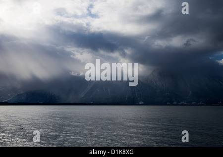 Blick über den Genfer See mit Wolken, Sonnenstrahlen und Berge, genommen von Veytaux, Schweiz Stockfoto