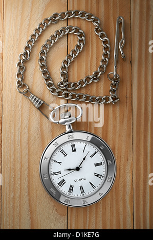 Foto von Silber Vintage Taschenuhr mit Kette auf hölzernen Hintergrund Stockfoto
