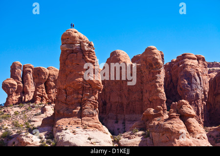 Zwei Bergsteiger auf einem Sandsteinfelsen spire oder pinnacle Arches-Nationalpark in der Nähe von Moab Utah USA Vereinigte Staaten von Amerika uns Stockfoto