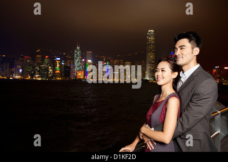 Glückliches junges Paar genießen die Nacht Blick auf Victoria Harbour, Hongkong Stockfoto