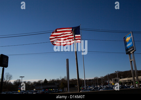 Eine große amerikanische Flagge fliegt über einem Chevrolet Autohaus viel in East Haven, Connecticut. Stockfoto