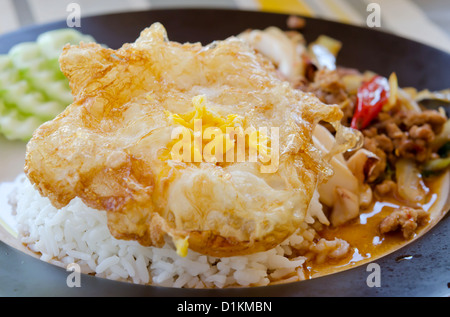 Nahaufnahme Spiegelei über Reis und Tintenfisch, gehacktem Schweinefleisch gebraten mit Chili-Pfeffer und Basilikum Stockfoto