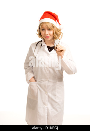 Attraktive blonde Frau Doktor in einem Kittel und Stethoskop stand lächelnd in eine rote Weihnachtsmütze, dreiviertel-Studio-Porträt Stockfoto