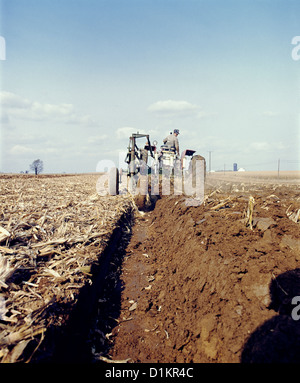 BAUER AUF DEM TRAKTOR HANDELN FALLEN PFLÜGEN Stockfoto