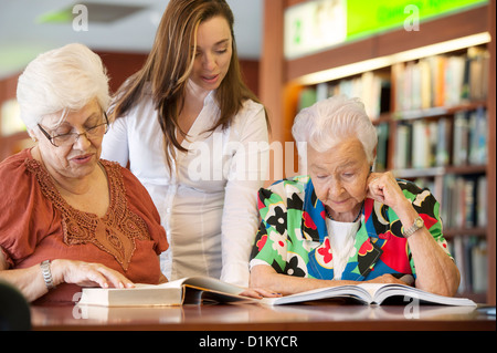 Spanisch Lehrer helfen ältere Schülern in Bibliothek Stockfoto
