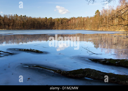 Eis bedeckt See Ustrych mit großen blauen Himmel Reflexionen. Stockfoto