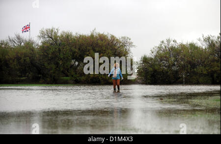 Worthing Sussex UK Spaziergänge 28. Dezember 2012 - eine Frau durch Hochwasser am Goring direkt am Meer in der Nähe von Worthing heute Stockfoto