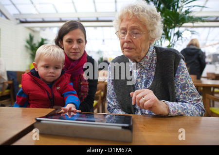 Großmutter, die mit ihrem Enkel einen Tablet-Computer benutzt, England, Vereinigtes Königreich Stockfoto