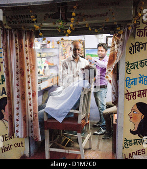 Ein Barbier rasiert sich ein Kunde im Ladengeschäft Friseure mit Wasser und Seife und Kehle Razer in Udaipur, Rajasthan Indien Stockfoto