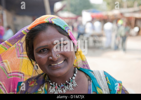 Eine lächelnde indische Frau in traditioneller Kleidung und tragen Schmuck lächelnd in die Kamera an einem heißen sonnigen Tag in Indien Pushkar Stockfoto