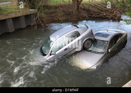 ZWEI AUTOS IN DEN FLUSS CAM IN HINXTON, ESSEX, FEST, NACHDEM SIE DURCH EINE ÜBERSCHWEMMTE STRAßE FUHREN. Stockfoto