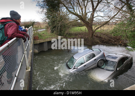 ZWEI AUTOS IN DEN FLUSS CAM IN HINXTON, ESSEX, FEST, NACHDEM SIE DURCH EINE ÜBERSCHWEMMTE STRAßE FUHREN. Stockfoto