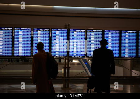 Passagiere, die Anzeigentafel am internationalen Flughafen Denver Colorado USA betrachten Stockfoto