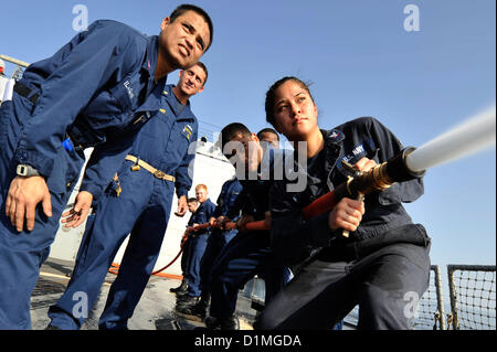 Matrosen behandeln einen Feuerwehrschlauch als Maschinen-Mechaniker 2. Klasse Erickson Ilagan, links, und Chief Boatswain's Mate Aaron Stewart bei Schadensbegrenzung Olympics an Bord der geführte Flugkörper-Zerstörer USS Jason Dunham (DDG-109) beobachten. Jason Dunham ist in den USA bereitgestellt 5. Flotte Aufgabengebiet Durchführung von maritimer Sicherheitsoperationen, Theater Sicherheitsbemühungen Zusammenarbeit und Unterstützung Missionen für die Operation Enduring Freedom. . Arabisches Meer (Dec.29, 2012) U.S. Navy Photo Stockfoto