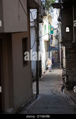 Einer alten indischen Mann in traditioneller Kleidung geht auf einen engen Verbündeten in Udaipur, Rajasthan, Indien Asien Stockfoto