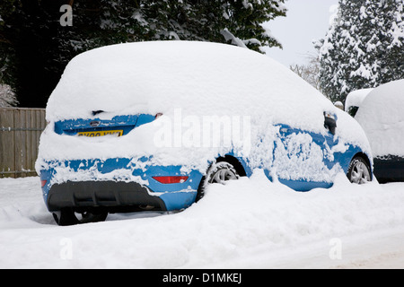 Dormansland, Surrey, England. Geparktes Auto auf der High Street bedeckt nach Blizzard dicken Schnee. Stockfoto