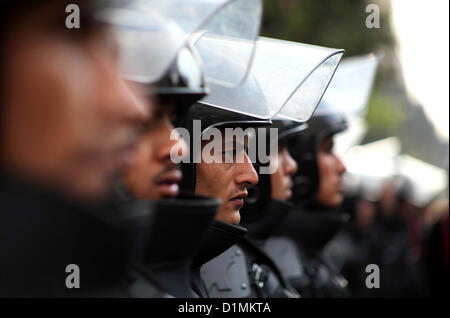 29. Dezember 2012 - Kairo, Ägypten - ägyptische Polizei Wache stehen außerhalb der Schura-Rat, das Oberhaus des Parlaments, als Demonstranten gegen Ägyptens Präsident Mohamed Morsi Gesang Parolen vor ihnen, während Mursi eine Rede vor einem neu ermächtigt Senat gibt. (Kredit-Bild: © Ashraf Amra/APA-Images/ZUMAPRESS.com) Stockfoto