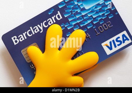 Gelbe Hände mit Barclaycard Visa-Kreditkarte auf weißem Hintergrund - hält an Geld Konzept für die Überwachung, die Kontrolle der Ausgaben Stockfoto