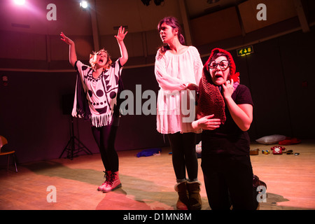 Drei junge Frauen, die Durchführung einer ausgearbeiteten improvisierte Komödientheater handeln, Kunstzentrum Aberystwyth, Wales UK Stockfoto