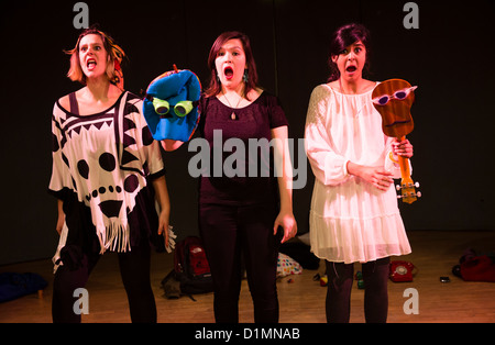 Drei junge Frauen, die Durchführung einer ausgearbeiteten improvisierte Komödientheater handeln, Kunstzentrum Aberystwyth, Wales UK Stockfoto