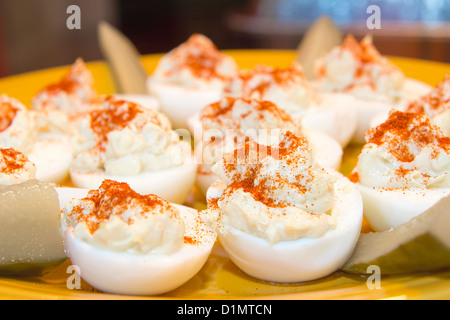 Platte des Deviled Eiern Hors d ' Oeuvre bestreut mit Paprikapulver würzen und Gurken Closeup Stockfoto