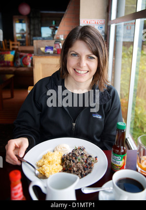 Junge Frau beim Frühstück von Eiern und Reis und Bohnen Gallo Pinto im Poas Lodge and Restaurant, Alajuela, Costa Rica. Stockfoto