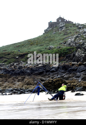 Einsamer Strand Fischer an einem kalten nassen Sommertag in St. Ives, Cornwall. 17. August 2012 Stockfoto