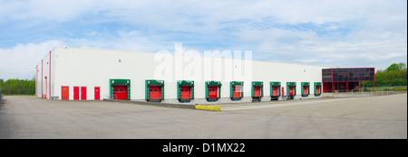 Panorama Blick auf die Vorderseite einer Industriehalle mit nummerierten roten Laderampen Stockfoto