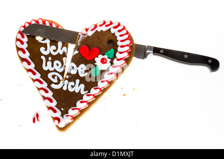 Lebkuchenherz, in zwei Stücke schneiden, Symbol für fertige Liebe, Beziehung. Sagen, ich liebe dich in deutscher Sprache. Stockfoto