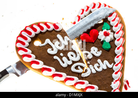 Lebkuchenherz, in zwei Stücke schneiden, Symbol für fertige Liebe, Beziehung. Sagen, ich liebe dich in deutscher Sprache. Stockfoto