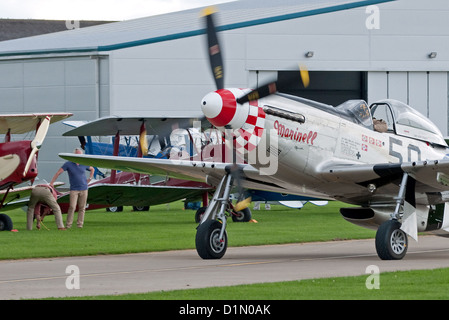 Gut erhaltene p-51 Mustang Kämpfer Taxis in vorbei an einer Reihe von Oldtimer-Flugzeugen auf der Unternehmen Air Show 2012 Stockfoto