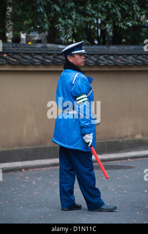 Ein Sicherheitsbeamter, der die riesigen Touristenmassen lenkt, die kommen, um das berühmte Herbstlaub in Tofuku-ji, Kyoto, Japan, zu sehen Stockfoto