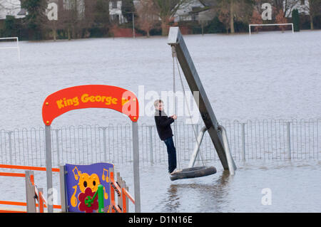 Hereford, Großbritannien. 30. Dezember 2012. Ein Junge spielt auf dem überfluteten Spielplatz. Familien machen Sie das beste von überfluteten König George V Recreation Ground. Die Einheimischen sagen, dass die Flut zu den höchsten liegen, dass sie dieses Jahr gesehen habe. Umleitungen sind auf den Straßen zwischen Hereford und Brecon. Foto von Graham M. Lawrence/Alamy Live-Nachrichten. Stockfoto