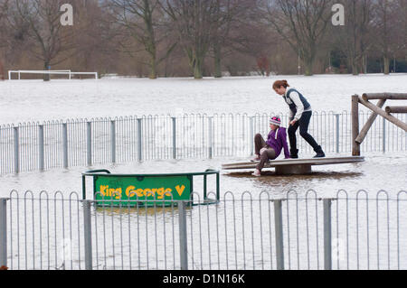 Hereford, Großbritannien. 30. Dezember 2012. Zwei Kinder spielen auf dem Spielplatz überflutet. Familien machen Sie das beste von überfluteten König George V Recreation Ground in Hereford. Die Einheimischen sagen, dass die Flut zu den höchsten liegen, dass sie dieses Jahr gesehen habe. Umleitungen sind auf den Straßen zwischen Hereford und Brecon. Foto von Graham M. Lawrence/Alamy Live-Nachrichten Stockfoto