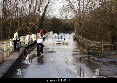 Offchurch, UK. Sonntag, 30. Dezember 2012. Autos und Radfahrer aushandeln eine überflutete Straße in der Nähe von Offchurch, Leamington Spa, Warwickshire, wo der Fluß Leam seinen Ufern wieder geplatzt ist. Bildnachweis: Alan Spencer/Alamy Live-Nachrichten Stockfoto