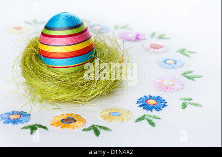 Handgefertigte Osterdekorationen auf einem bestickten Tischdecke Stockfoto