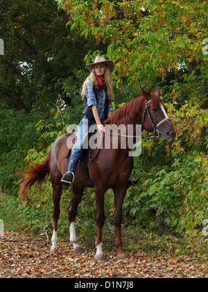 Junge Cowgirl auf Reiten eine Spur in den Nachmittag Tageslicht Stockfoto