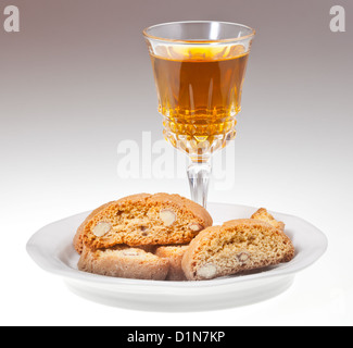 Kristallglas mit süßen Weißwein und italienischer Mandel-Cantuccini auf Untertasse Stockfoto