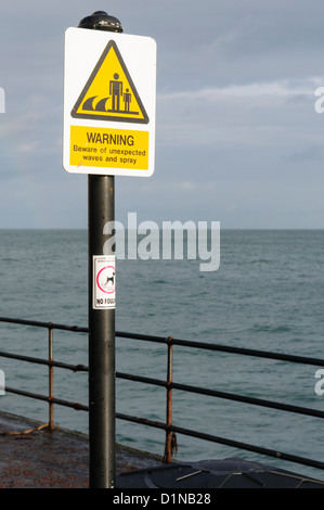 Unterzeichnen Sie Warnung der Öffentlichkeit die Gefahr der unerwartete Wellen zu und sprühen Sie entlang einer gefährlichen Küste Stockfoto