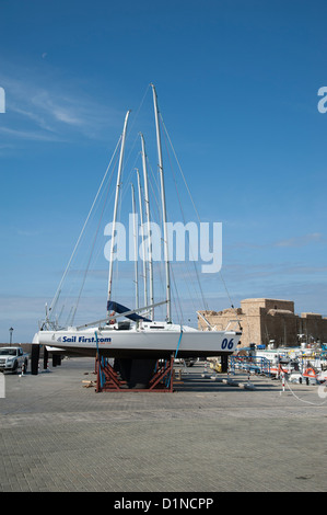 Erste Unternehmen J 80 Yachten zu segeln, auf dem Kai in Paphos Zypern mit einer Kulisse der mittelalterlichen Festung Stockfoto