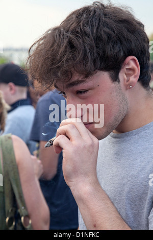 Eine Jugend raucht eine große Hand gerollt Zigarette bei einem Protest fordern die Legalisierung von Cannabis im Londoner Hyde Park Stockfoto