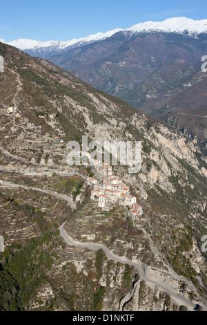 LUFTAUFNAHME. Mittelalterliches Dorf oberhalb des Tinée Vallée, Mercantour Alpen in der Ferne. Bairols, das Hinterland der französischen Riviera, Frankreich. Stockfoto