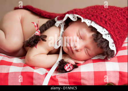 Neugeborenes Babymädchen trägt ein Little Red Riding Hood Kostüm Stockfoto